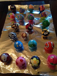 there are many different colored balls on the sheeted tablecloth, and one is decorated with an animal face