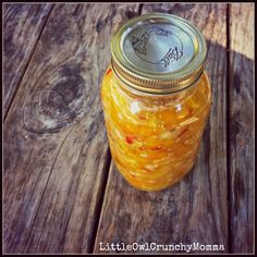 a jar filled with yellow liquid sitting on top of a wooden table