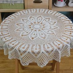 a white doily sitting on top of a wooden table