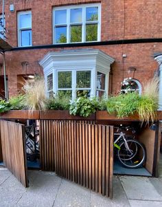 a bike is parked next to a wooden planter