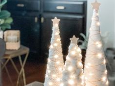 three white christmas trees with lights on them