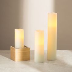 three lit candles sitting next to each other on a table