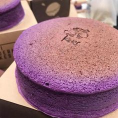 a purple cake sitting on top of a table next to a pair of black scissors