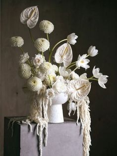 a white vase filled with flowers on top of a table