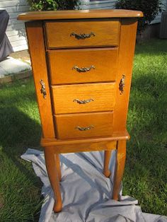 a wooden dresser sitting on top of a grass covered field