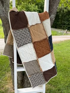 a blanket is hanging on the back of a white chair in front of a tree