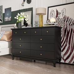 a bedroom with black and white decor on the walls, bed and dresser in it