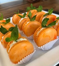 small desserts are arranged on a white plate with mint garnishes in them