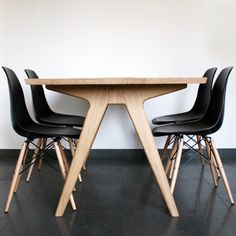 two black chairs sitting at a table with a white wall in the backround