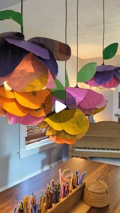 a bunch of paper flowers hanging from the ceiling in a room with wooden flooring