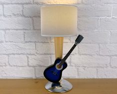 a blue guitar lamp sitting on top of a wooden table