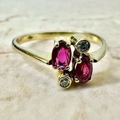 Fine vintage handcrafted 18 Karat yellow gold Toi-Et-Moi (bypass) ring set with 2 oval rubies weighing approximately 0.50 carat, and 2 round diamonds weighing approximately 0.05 carat, F-G VS. Stamped 750 with maker’s marks. This ring is a size 7.75 US / P 1/2 UK. > Resizing not included. This ring can be resized to fit most fingers. Please contact us for details. Resized rings are final sale. It weighs 2.3 grams. Birthstone: July/April. Condition: Very good. Minute scratches throughout metal. L Oval Ruby Ring With Three Diamonds, Oval Three Stone Ruby Ring With Diamonds, Gold Oval Ruby Ring With Three Stones, Gold Ruby Ring With Three Stones, Oval Shaped, Vintage Oval Three-stone Ruby Ring, Oval Multi-stone Ruby Ring, Three Stone Oval Ruby Ring, Gold Oval Ruby Ring With Diamond Accents, Oval Multi-stone Ruby Ring In 14k Gold