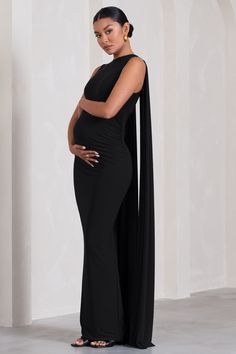 From weddings to black tie galas. Allora is the perfect addition to any formal wardrobe. Defined by an extravagant cape. this classic black maternity maxi boasts a crew neckline. subtle bump ruching and form-flattering silhouette. Try styling Allora with a sleek bun at your next event to give its cape the attention it deserves. Features - Premium stretch jersey- Crew neckline- Sleeveless - Cape detail- Invisible zip closure - Bump ruching- Maxi length Sizing & Fit Model is 5'9" and wears US size Pregnant Black Tie Dress, Pregnancy Red Carpet Dresses, Pregnancy Fashion Black Women, Black Formal Maternity Dress, Black Cocktail Outfit, Classy Maternity Outfits, Pregnant Dress Elegant, Maternity Evening Gowns, Elegant Maternity Dresses