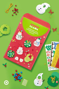 an assortment of christmas decorations and stickers on a green surface with other holiday items