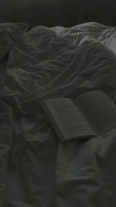 an open book laying on top of a bed