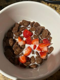 a white bowl filled with cereal and strawberries