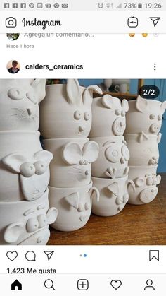 several white ceramic vases sitting on top of a wooden table