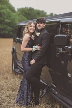 a young man and woman standing in front of a limo with their arms around each other