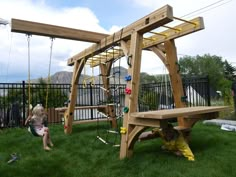 a wooden swing set sitting on top of a lush green field