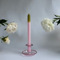 a pink candle and some white flowers on a table