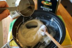 a person stirring something in a bowl with a spoon