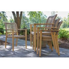 three wicker chairs sitting on top of a patio next to a table and chair