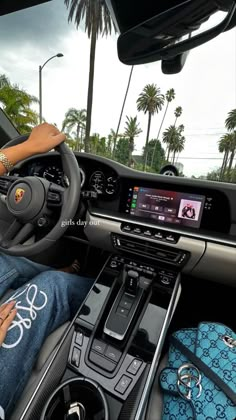 a woman sitting in the driver's seat of a car with her hand on the steering wheel