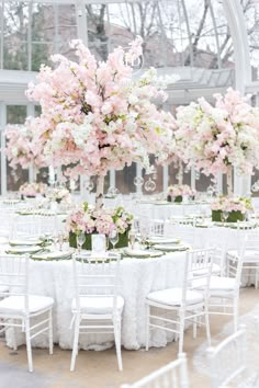 the tables are set with white linens and pink flowers