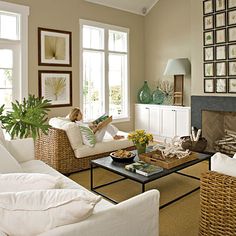 a woman sitting on a couch in a living room next to a fire place and windows