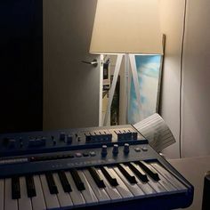 an electronic keyboard sitting in front of a lamp