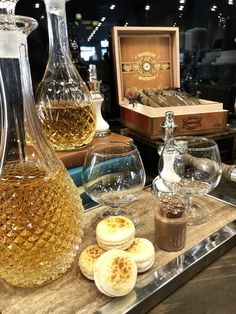 bottles and glasses filled with different types of liquid on a table next to other items