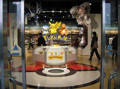 the entrance to a pokemon store with people walking by