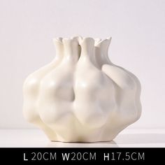 a white vase sitting on top of a table