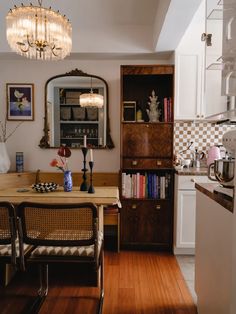 a dining room table and chairs in front of a bookshelf