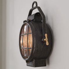 an old - fashioned light fixture is mounted on the wall, with a wooden handle