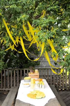 a picnic table is set up with yellow streamers