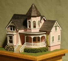 a pink doll house sitting on top of a wooden table