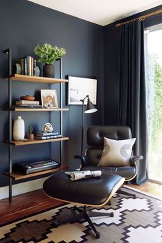 a living room with a chair and shelves on the wall next to a large window