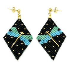 a pair of black and blue beaded earrings with gold accents on each earring