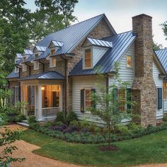 a large white house with lots of windows and metal roofing on top of it