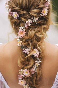 a woman with long hair and flowers in her hair is wearing a flowery braid