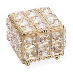 a gold and crystal jewelry box sitting on top of a white surface