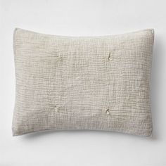 a white pillow with buttons on the front and back of it, against a white background