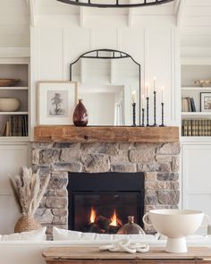 a living room filled with furniture and a fire place in front of a stone fireplace