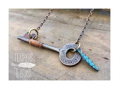 a necklace with an old key and feather charm