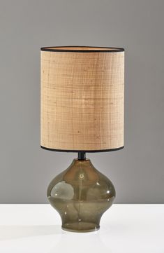 a lamp that is on top of a table with a cloth shade over the base