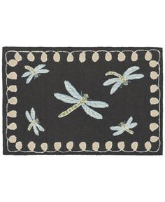 a black door mat with dragonflies on it