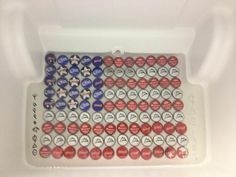 an american flag made out of red, white and blue buttons in a plastic container