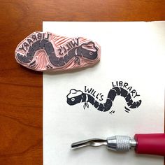 a rubber stamp with an image of a snake on it next to a pair of scissors