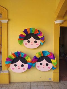 two paper plates with faces on them sitting in front of a yellow wall next to a doorway